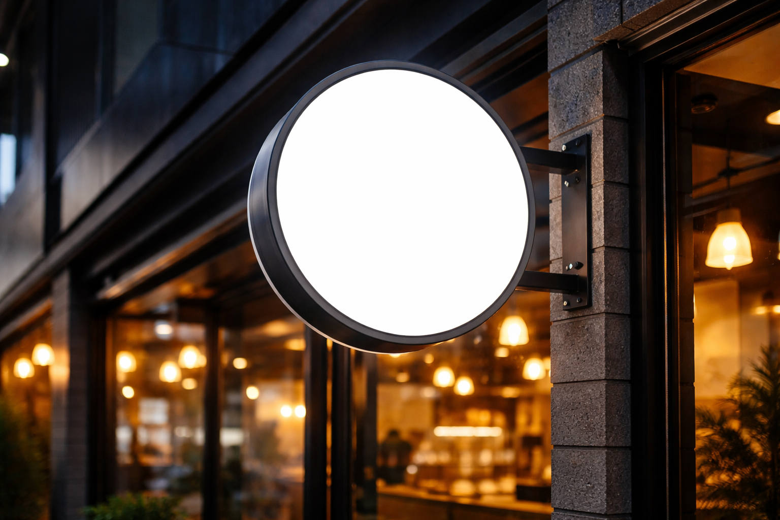 Neon box akrilik menyala terang menampilkan logo kafe modern di pinggir jalan.