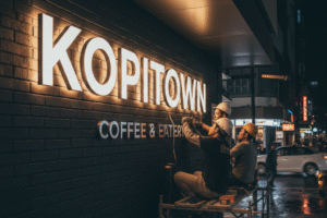 Pemasangan huruf timbul custom akrilik menyala untuk toko di area Bekasi yang terlihat profesional saat malam hari.