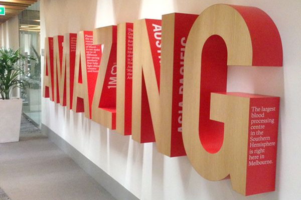 Huruf timbul akrilik dan stainless dengan LED terpasang rapi pada фасad toko modern terlihat elegan dan profesional